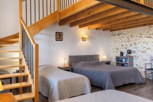 a bedroom with two beds and a staircase at Chambres D'hôtes Les Carmes in La Flocellière