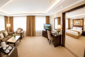 a large hotel room with a bed and a desk at Flower Hotel Ulaanbaatar in Ulaanbaatar