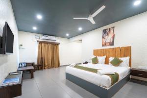 a bedroom with a large bed and a television at Sia Signature Calangute in Calangute