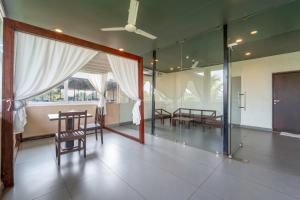 a dining room with a table and chairs and glass doors at Sia Signature Calangute in Calangute