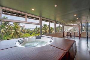 a large bath tub in a room with large windows at Sia Signature Calangute in Calangute