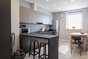 a kitchen with a black counter and stools in it at Apartament 16 in Sandomierz