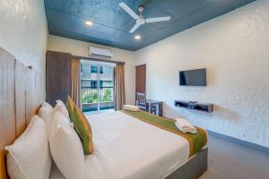 a bedroom with a large bed and a tv at Sia Signature Calangute in Calangute +45 photos
