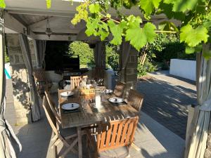 a wooden table and chairs on a patio at Les Hortensias in Lantosque