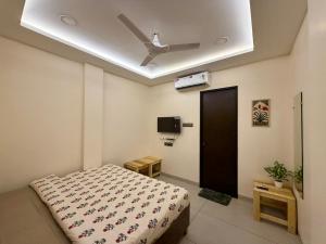 a bedroom with a bed and a ceiling fan at Yatha sukham Prutham in Ujjain +35 photos