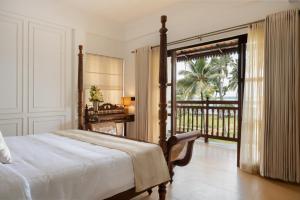 a bedroom with a bed and a view of a balcony at Sanskreti in Cochin +39 photos
