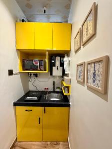 a kitchen with yellow cabinets and a sink at Yatha sukham Prutham in Ujjain