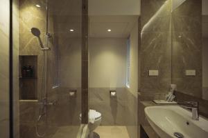 a bathroom with a shower and a toilet and a sink at Hotel Holm Bangkok in Bangkok