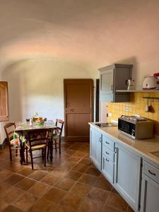 a kitchen with a table and a dining room at Agriturismo Coppi Rossi in Imperia