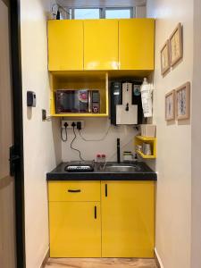 a kitchen with yellow cabinets and a sink at Yatha sukham Prutham in Ujjain