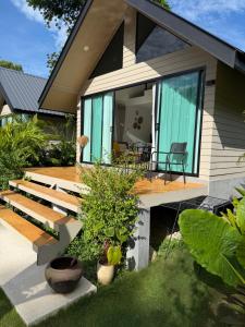 a house with green shutters and a deck at Good Mood Bungalows in Ko Phangan