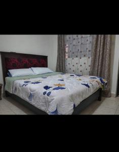 a bedroom with a bed with a blue and white blanket at Limuru stays in Ngecha