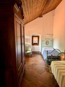 a bedroom with a bed and a chair in a room at Agriturismo Coppi Rossi in Imperia