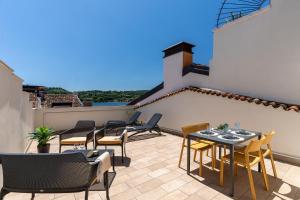 a patio with chairs and tables on a roof at Aromi Piccolo Hotel in Salò