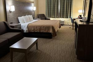 a hotel room with a bed and a couch at Quality Inn Forsyth Decatur in Forsyth