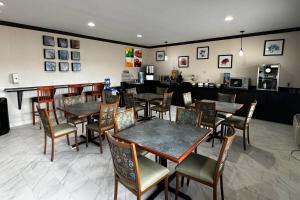 a restaurant with tables and chairs and a counter at Quality Inn Forsyth Decatur in Forsyth