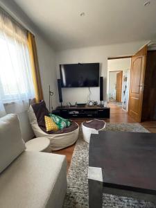 a living room with a couch and a flat screen tv at Gellénia in Balatonberény