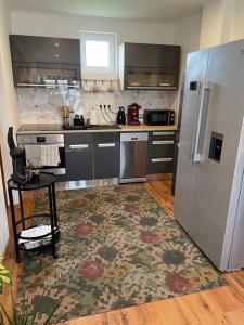 a kitchen with a stainless steel refrigerator and a rug at Gellénia in Balatonberény