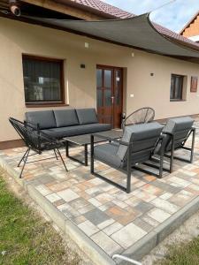 a patio with two chairs and a bench on a patio at Gellénia in Balatonberény