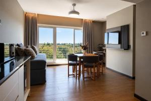 a kitchen and living room with a table and chairs at Radisson Red Funes in Rosario
