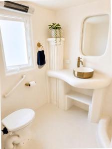 a white bathroom with a sink and a toilet at Little Mykonos right here in Stanthorpe! in Stanthorpe +19 photos