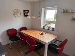 a dining room with a wooden table and red chairs at FEWO in Spielberg in Sachsenheim