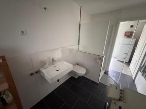 a white bathroom with a sink and a toilet at FEWO in Spielberg in Sachsenheim +6 photos
