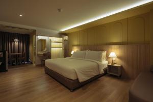 a bedroom with a large bed and a desk at Hotel Holm Bangkok in Bangkok