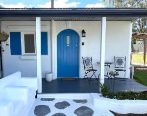 a front porch with a blue door and a table at Little Mykonos right here in Stanthorpe! in Stanthorpe