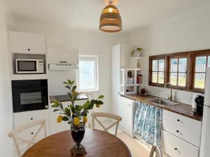 a kitchen with a wooden table with a vase on it at Little Mykonos right here in Stanthorpe! in Stanthorpe