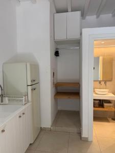 a white kitchen with a sink and a refrigerator at Armiriki Seaside in Kamares +55 photos