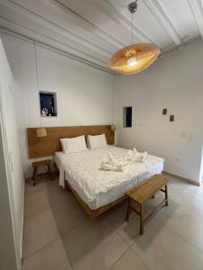 a bedroom with a bed and a bench and a chandelier at Armiriki Seaside in Kamares
