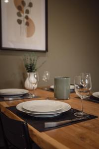 a wooden table with plates and wine glasses on it at Apartment Claussen 1 in Bremerhaven +3 photos