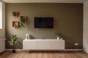 a living room with a white cabinet and a flat screen tv at Apartment Claussen 1 in Bremerhaven
