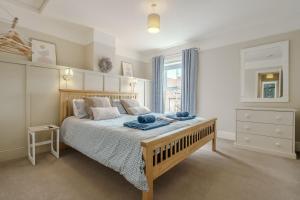 a bedroom with a large bed and a window at Beachcomber, Dog-Friendly Coastal Cottage Close to the Beach in Winterton-on-Sea