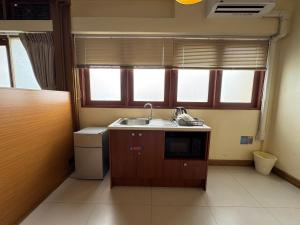 a small kitchen with a sink and a dishwasher at Sukstay Hotel in Bangkok +37 photos