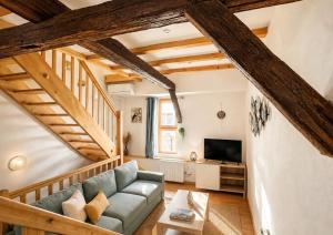 a living room with a couch and a tv at L'Atypique in Eguisheim +2 photos
