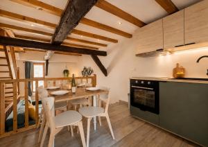 a kitchen and dining room with a table and chairs at L'Atypique in Eguisheim