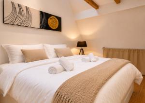 a bedroom with a large white bed with white pillows at L'Atypique in Eguisheim