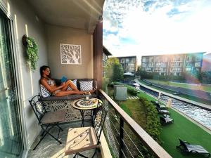 a man sitting on a balcony reading a book at Resort-Style 1BR-Epic Pool View-Walk to Beach in Bophut