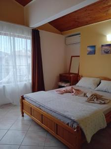 a bedroom with a bed and a window at Guest House Sun in Kranevo