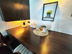 a wooden table with two cups and a mirror at Resort-Style 1BR-Epic Pool View-Walk to Beach in Bophut