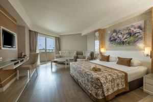 a hotel room with a bed and a living room at Crystal Sunset Pearl Collection - Ultimate All Inclusive in Side