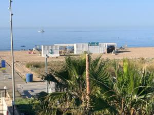a view of a beach with a house and the ocean at MarPlana in Castelldefels