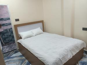 a white bed with a pillow on top of it at HOTEL अtithi in Rājgīr