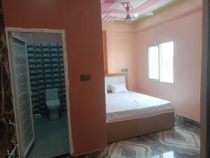 a bedroom with a bed and a bathroom with a window at HOTEL अtithi in Rājgīr +19 photos