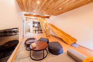 a living room with a staircase and a table and chairs at Tomareru Himitsukichi L-Base in Matsumoto
