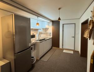 a kitchen with a stainless steel refrigerator and a window at Damyang Hwayang in Damyang
