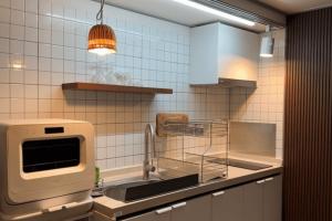 a kitchen with a sink and a microwave at Damyang Hwayang in Damyang