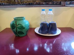 a table with a vase and two bottles of water at Home Dwarka in Arambol